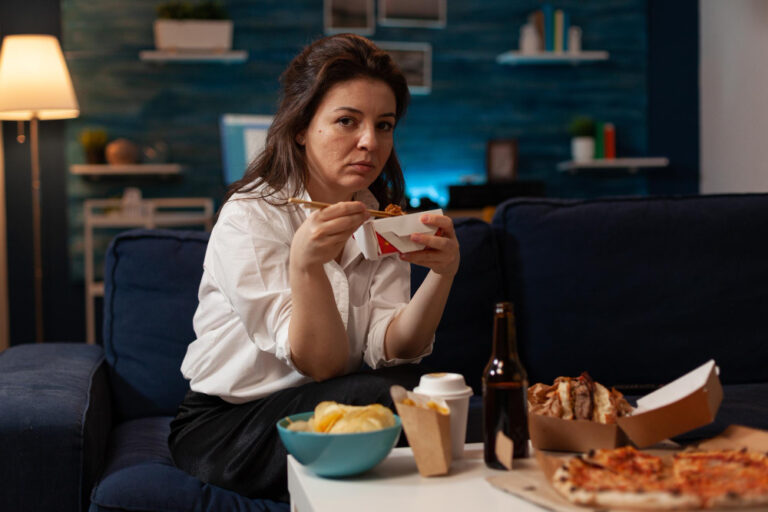 Portrait Smiling Woman Eating Takeout Asian Noodles With Chopsticks Living Room Sofa Office Worker Sitting Couch Evening Enjoying Chinese Takeaway Ramen Box Delicious Junk Food